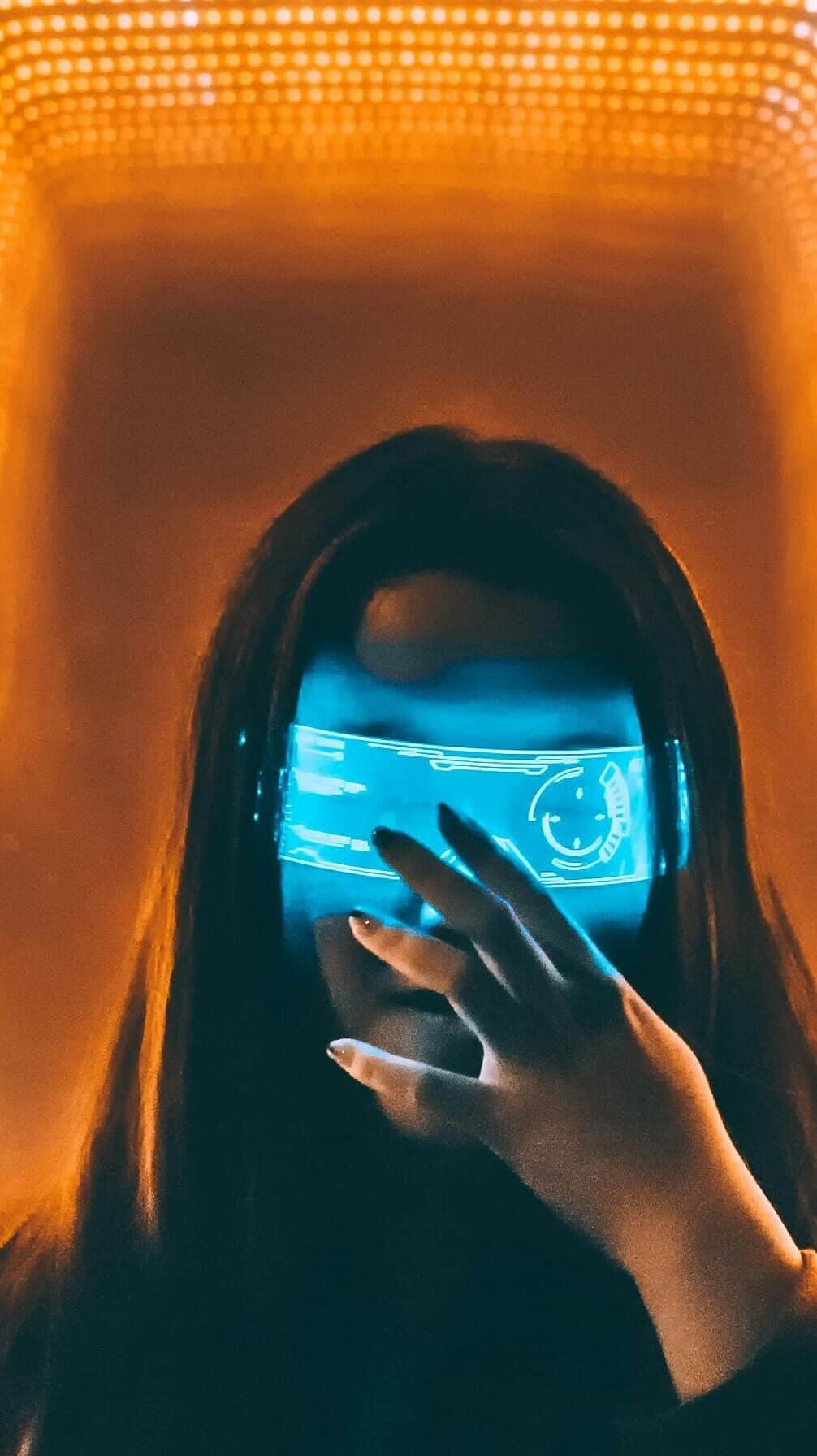 Person wearing an augmented reality headset with a glowing blue holographic interface overlay