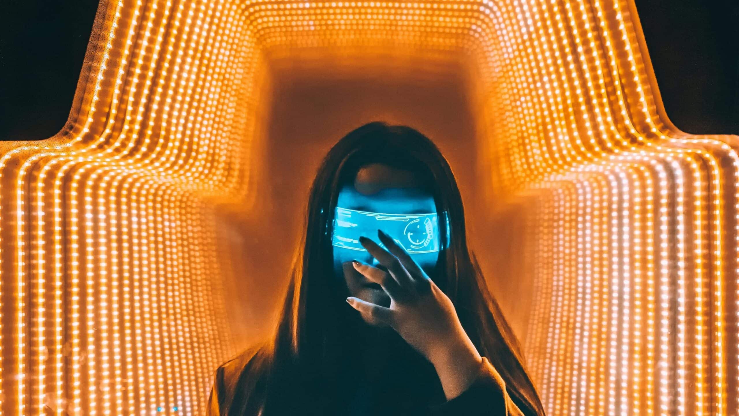 Person in an orange LED-lit futuristic environment interacting with holographic AR technology